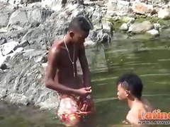 Teen gay swimmer playfully going down in the river